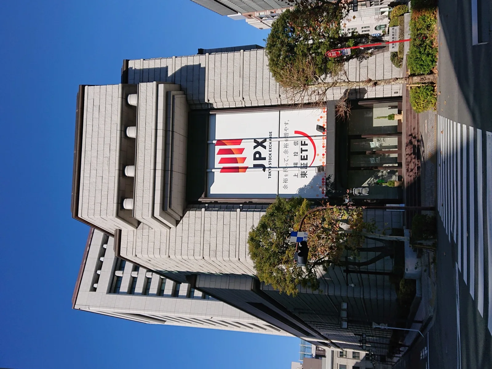 証券取引所の電光掲示板に表示される株価と配当関連の数値を見つめる投資家たち